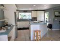Bright kitchen featuring white cabinets, stainless steel appliances, and natural light from the window at 3788 Fir Ct, Ormond Beach, FL 32174