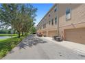 Rear view of townhouse garages along the street, complemented by a tranquil lakeside view at 4297 Regal Town Ln, Lake Mary, FL 32746
