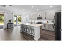 Modern kitchen featuring stainless steel appliances, a large island with seating, and light gray cabinetry at 518 Briarbrook Way, Deland, FL 32724