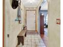 Inviting entryway featuring tiled floors, a wooden bench, and an archway leading to other rooms at 5967 Plantera Ct, Port Orange, FL 32127