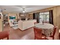 Spacious living room with a brick fireplace, wood-paneled walls, and sliding glass doors to the lanai at 5967 Plantera Ct, Port Orange, FL 32127
