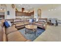 Spacious living room boasts a leather sectional, open to the kitchen and dining area at 6254 Woodhaven Village Dr, Port Orange, FL 32128