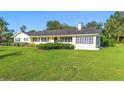 Charming single-story home with lush green lawn and mature landscaping at 701 N Tuxedo Ave, Deland, FL 32724