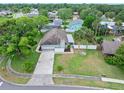 Aerial view of a home with a well-manicured lawn, palm trees, and an inviting arched entryway at 718 Sleepy Hollow Dr, Port Orange, FL 32127