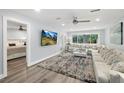 Light-filled living room with neutral walls, ceiling fan, large windows, and an adjacent bedroom at 809 E 14Th Ave, New Smyrna Beach, FL 32169
