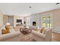Bright living room featuring a white-painted brick fireplace and neutral-toned furniture at 825 Wells Dr, South Daytona, FL 32119