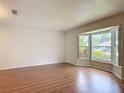 Bright room featuring hardwood floors, neutral walls, and a large bay window overlooking the yard at 832 Wildwood Cir, Port Orange, FL 32127