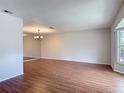 Spacious living room featuring hardwood floors, natural light from bay window, and mirrored wall at 832 Wildwood Cir, Port Orange, FL 32127
