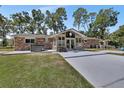 Backyard view with brick patio and hot tub, with lush greenery and an enclosed sunroom at 851 W Wisconsin Ave, Orange City, FL 32763