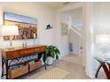 Inviting entryway featuring a decorative table, neutral paint, tile floors, and staircase at 918 Noble Run, New Smyrna Beach, FL 32168