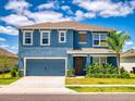 Charming two-story home with a blue facade, a well-kept lawn, and a welcoming two car garage at 918 Noble Run, New Smyrna Beach, FL 32168