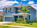 Lovely two-story home featuring light blue siding, a manicured lawn, and mature landscaping at 918 Noble Run, New Smyrna Beach, FL 32168