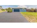 Side view of single story home with a dark blue garage door and matching trim at 1032 Bel Aire Dr, Daytona Beach, FL 32118