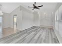 Bright living room with vaulted ceilings, a chandelier, gray wood flooring, and tile entryway at 1141 Glendale Ave, Deltona, FL 32725