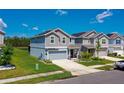 A beautifully landscaped home featuring solar panels, a manicured lawn and a paved driveway at 1183 Cabot Cliffs Dr, Daytona Beach, FL 32124