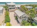 A home with lush tropical landscaping sits on a beach with an adjacent matching smaller living quarter at 1209 N Atlantic Ave, New Smyrna Beach, FL 32169