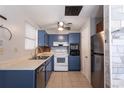 Kitchen with blue cabinets, tiled floor, stainless appliances, and a decorative ceiling at 1284 Vanderbilt Dr, Ormond Beach, FL 32174