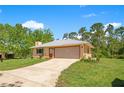 A spacious single-story home with a large two-car garage and a concrete driveway on a lush green lawn at 140 Rodeo Rd, Ormond Beach, FL 32174