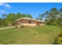 A single-story home featuring a two-car garage, concrete driveway and a well-maintained lawn and tropical landscaping at 140 Rodeo Rd, Ormond Beach, FL 32174