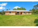 Charming single-story home featuring a metal roof and a sprawling green lawn with an inviting, colorful front door at 140 Rodeo Rd, Ormond Beach, FL 32174