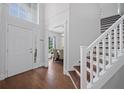 Inviting foyer with wood flooring, staircase, and a view into the adjacent dining room at 1491 Nappa Dr, Port Orange, FL 32128
