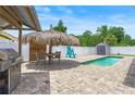Backyard features a refreshing pool, tiki bar, and brick paver patio, perfect for outdoor entertaining at 1491 Nappa Dr, Port Orange, FL 32128