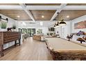 Spacious living area features wood ceiling, pool table, and flows into the kitchen with a breakfast bar at 160 Point O Woods Dr, Daytona Beach, FL 32114