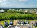Wide aerial shot of a new development featuring multiple homes, green spaces, and distant water views at 16241 Honey Harvest St, Winter Garden, FL 34787