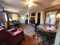 Cozy living room featuring wood floors, wood paneling, ceiling fans, and a wood burning stove at 1880 N Sparkman Ave, Orange City, FL 32763