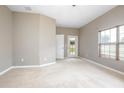 Spacious bedroom with neutral carpet, baseboard trim, and door to the outdoor space at 201 Dyson Dr, Deland, FL 32724