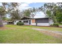 Single-story house with a well-manicured lawn and updated exterior colors and trim at 2215 Lake Ruby Rd, Deland, FL 32724