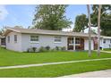 Single-story home with neat lawn, brick detail, and attached carport offers charming curb appeal at 2226 Sherwood Dr, South Daytona, FL 32119