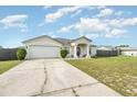 Single-story home boasts an attached garage, manicured front yard, and covered entry, under a sunny sky at 2884 Sweet Springs St, Deltona, FL 32738