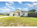 Inviting single-Gathering home with a well-kept lawn, attached garage, and charming front entrance, bathed in sunlight at 2884 Sweet Springs St, Deltona, FL 32738
