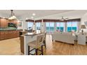 Modern kitchen and living room featuring an island bar, granite counters and ocean views at 2901 S Atlantic Ave # 401, Daytona Beach Shores, FL 32118