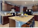 Well-lit kitchen featuring dark wood cabinets, stainless steel appliances, a central island with seating, and generous counter space at 2919 Sime St, New Smyrna Beach, FL 32168