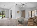 Bright living room featuring neutral carpet, a ceiling fan, and a glass door leading to the lanai at 2980 Lockwood Blvd, Deltona, FL 32738