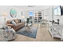 Bright living room featuring comfortable seating, stylish decor, and access to a balcony at 2987 S Atlantic # 606, Daytona Beach Shores, FL 32118