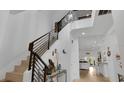 Bright foyer boasts high ceilings, modern chandelier, staircase with decorative railing, and views into other living spaces at 302 Tammie Sue Ln, Deland, FL 32724