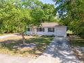 A single-story house with a driveway and lawn, partially obscured by trees at 31 Lake Dr, Debary, FL 32713