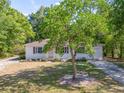 View of a single-story house with a well-maintained lawn, driveway and mature tree at 31 Lake Dr, Debary, FL 32713