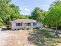 A single-story house with a driveway and lawn surrounded by trees at 31 Lake Dr, Debary, FL 32713