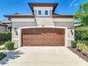 A close up shot of the two-car garage featuring a decorative top and landscaped surroundings at 3148 Bailey Ann Dr, Ormond Beach, FL 32174