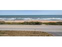 Beautiful beach view featuring blue ocean water, a sandy beach, and a road at 3170 Ocean Shore Blvd # 5010, Ormond Beach, FL 32176