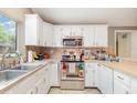 Cozy kitchen with white cabinets, stainless steel appliances, and a bright window over the sink at 32811 County Road 473, Leesburg, FL 34788