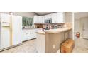 Bright kitchen featuring tiled floors, white cabinets, and breakfast bar area for seating at 32811 County Road 473, Leesburg, FL 34788