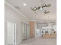 Bright living room with wood flooring, ceiling fan, and open floor plan leading into the kitchen at 3402 Torre Blvd, New Smyrna Beach, FL 32168