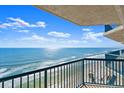 Balcony shot showing ocean view with a blue railing in the foreground and blue sky with fluffy clouds at 3425 S Atlantic Ave # 1602, Daytona Beach, FL 32118