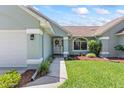 Inviting front exterior with lush landscaping, and a covered entrance to the home at 35 China Moon Dr, Ormond Beach, FL 32174