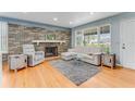 Inviting living room featuring a stone fireplace, hardwood floors, and bright natural light at 355 Hartford Ave, Daytona Beach, FL 32118